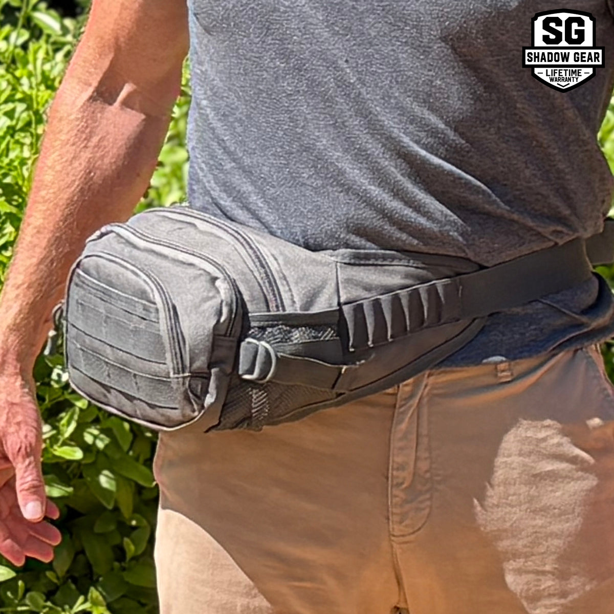 Man wearing the Shadow Gear Dash 4L tactical waist pack in Charcoal at the hip, showing front MOLLE webbing