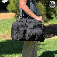 Man carrying the Shadow Gear Traverse 18 42L tactical MOLLE duffel bag in Black by the top handles with the shoulder strap
