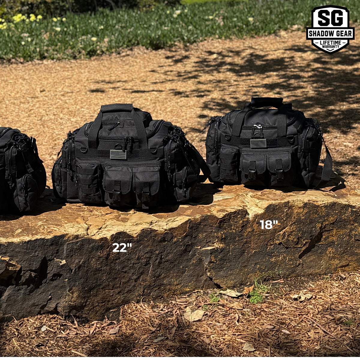 Shadow Gear Traverse tactical duffel bags in Black on a rock, 22 inch and 18 inch sizes side by side for size comparison