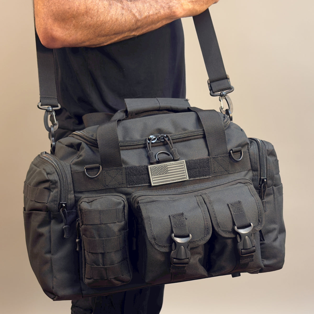 Man carrying the Shadow Gear Traverse 18 42L tactical MOLLE duffel bag in Black by the shoulder strap, studio lifestyle shot